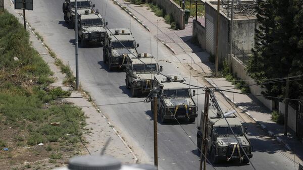 A convoy of army vehicles is seen during an Israeli military raid on the militant stronghold of the Jenin refugee camp in the occupied West Bank, Monday, July 3, 2023. Israeli drones struck targets and deployed hundreds of troops in the area in the largest operation in the area in more than a year of fighting. Palestinian health officials said at least eight Palestinians were killed. - Sputnik India
