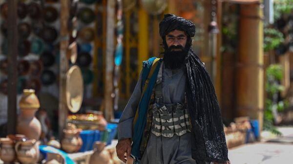 Сотрудник службы безопасности Талибана проходит мимо магазинов в Кабуле, Афганистан - Sputnik India