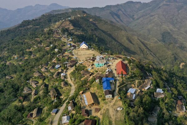 8 अप्रैल, 2023 को ली गई यह तस्वीर म्यांमार (दाएं) की सीमा से लगे भारत के नागालैंड राज्य के मोन जिले के लोंगवा गांव (बाएं) का हवाई दृश्य दिखाती है। (Photo by Arun SANKAR / AFP) - Sputnik भारत