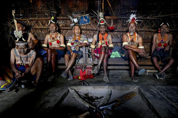8 अप्रैल, 2023 को ली गई यह तस्वीर भारत के नागालैंड राज्य के मोन जिले के होंगफोई गांव में एक पारंपरिक आदिवासी घर में सामुदायिक सभा के दौरान कोन्याक आदिवासियों को दिखाती है। (Photo by Arun SANKAR / AFP) - Sputnik भारत