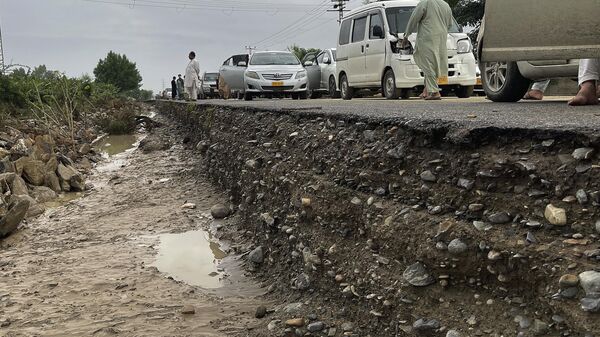 Travelers examine a damaged highway after flooding due to heavy rains, in Lasbella, a district in Pakistan's southwest Baluchistan province - Sputnik India