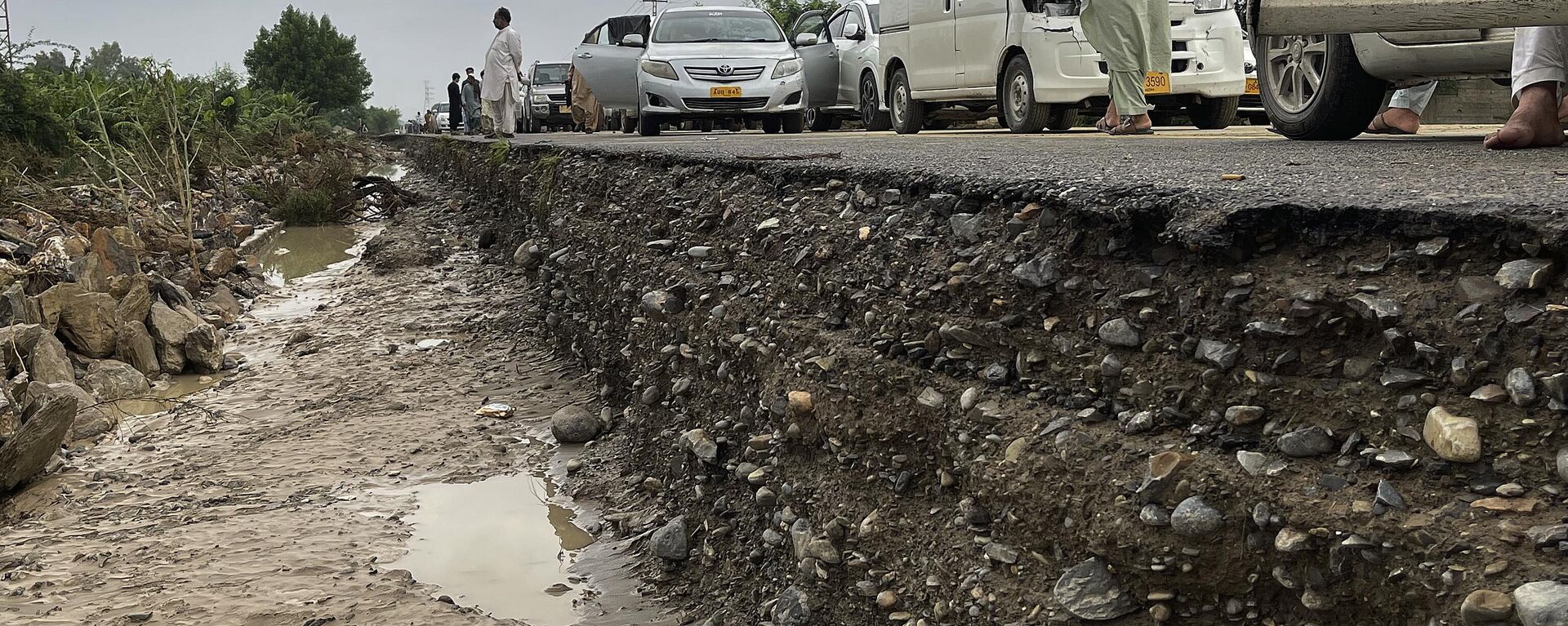 Travelers examine a damaged highway after flooding due to heavy rains, in Lasbella, a district in Pakistan's southwest Baluchistan province - Sputnik India, 1920, 23.08.2023