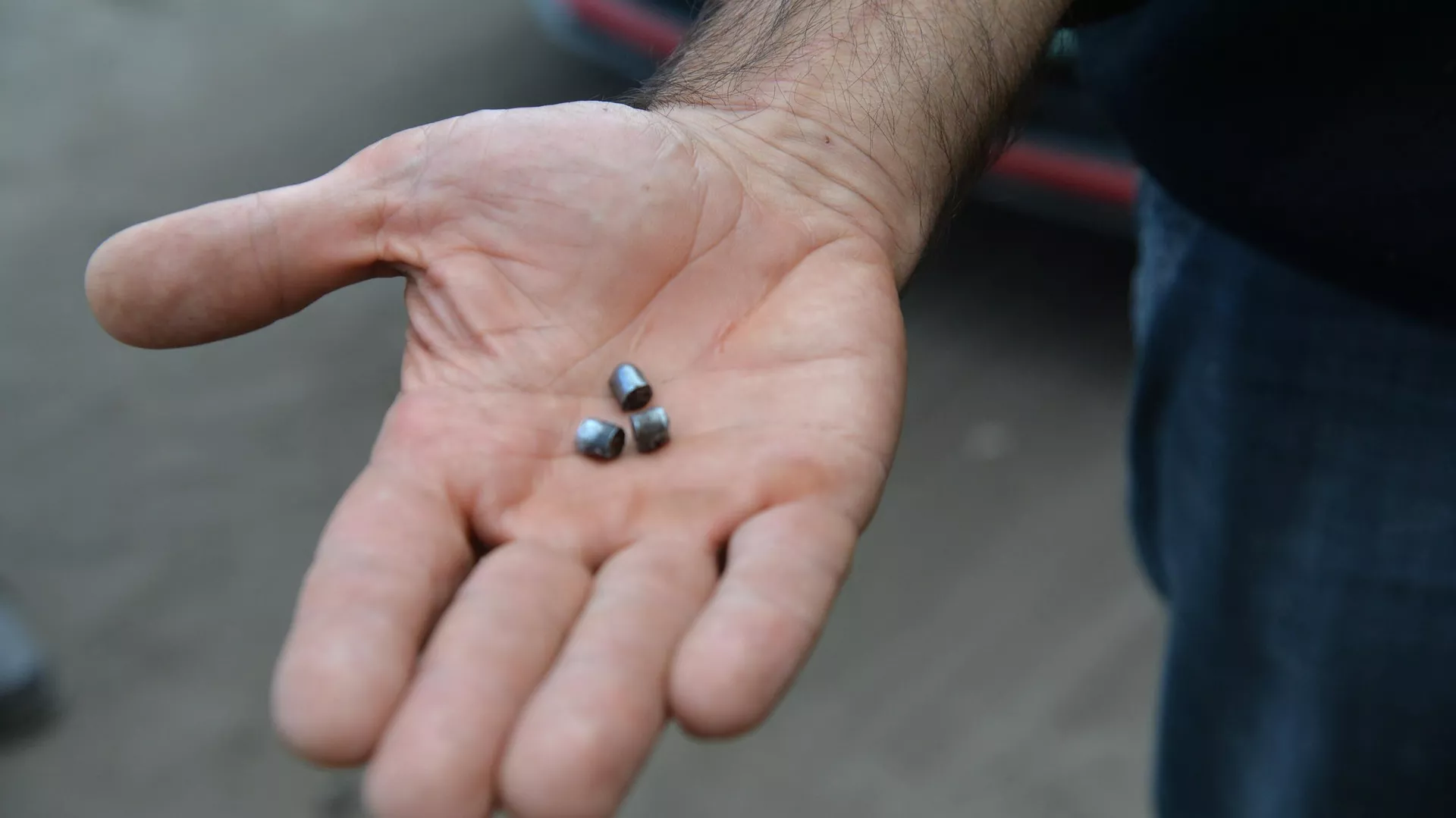 A man demonstrates fragments of cluster munition that were used to shell Kupyansk