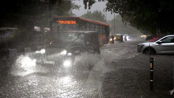 Vehicles move through a water logged street during a heavy downpour in New Delhi, India, Sunday, July 9, 2023.  - Sputnik India