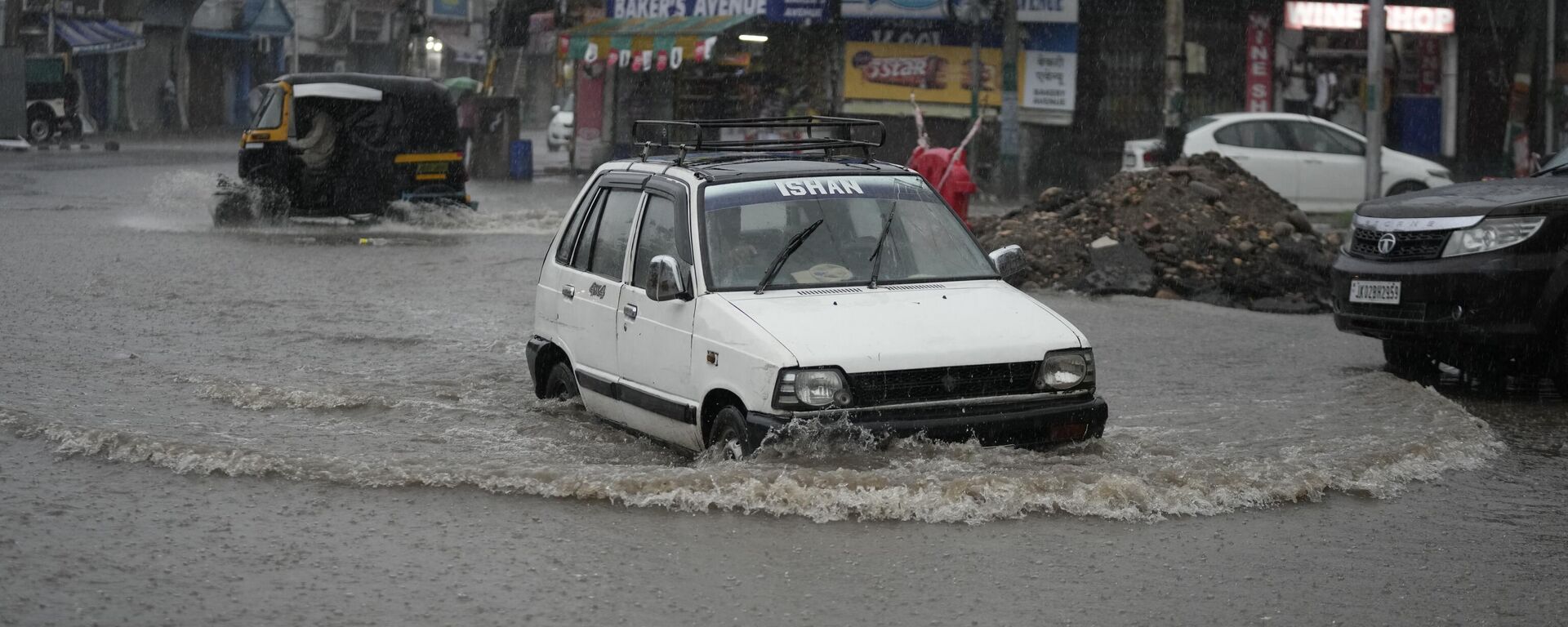 A car navigates its way through a flooded a street in Jammu, India - Sputnik भारत, 1920, 11.07.2023
