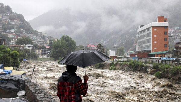 A man looks at a swollen River Beas following heavy rains in Kullu, Himachal Pradesh, India, Sunday, July 9, 2023. According to local reports heavy rain fall has triggered landslides, damaged houses and caused loss of lives. - Sputnik India