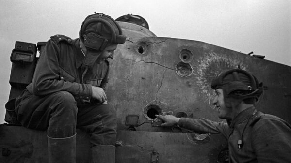 Two Soviet tankmen sitting on a disabled Tiger tank. The Kursk Bulge - Sputnik India