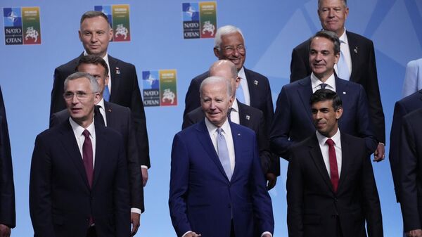 Front row from left, NATO Secretary General Jens Stoltenberg, President Joe Biden, and Britain's Prime Minister Rishi Sunak, second row from left French President Emmanuel Macron, German Chancellor Olaf Scholz, and Greek Prime Minister Kyriakos Mitsotaki, third row from left are, Polish President Andrzej Duda, Portugal's Prime Minister Antonio Costa and Romania's President Klaus Werner Iohannis, reacts at the conclusion of the family photo at the NATO summit in Vilnius, Lithuania - Sputnik भारत