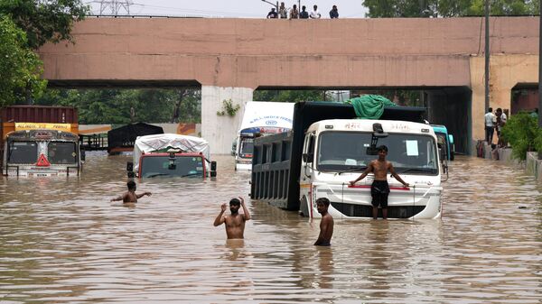 Vehicles navigate their way through a flooded underpass following heavy rainfall in New Delhi, India - Sputnik भारत