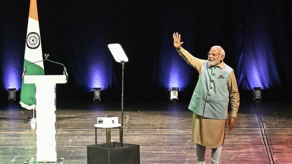 Indian Prime Minister Narendra Modi waves on stage as he delivers a speech at the Seine Musicale in Boulogne-Billancourt, Paris suburb on July 13, 2023. - Sputnik India