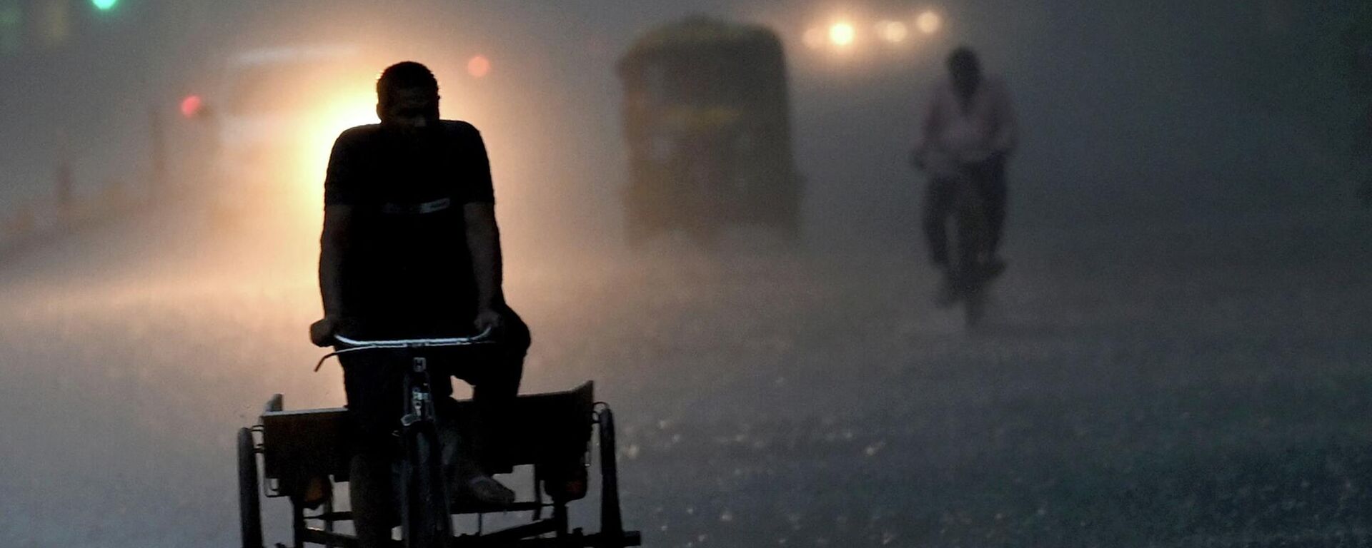 A man rides his cart along a street amid torrential rain in New Delhi on July 15, 2023. - Sputnik भारत, 1920, 17.07.2023