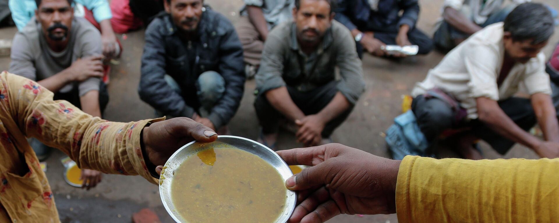 People wait for free food outside an eatery in Ahmedabad, India, on Jan. 20, 2021  - Sputnik India, 1920, 17.07.2023