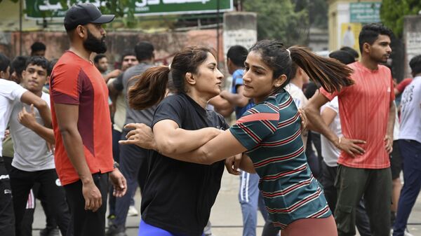 Indian wrestlers Vinesh Phogat, left, and Sangita Phogat practice wrestle as they participate in a protest against Wrestling Federation of India President Brijbhushan Sharan Singh and other officials in New Delhi - Sputnik भारत