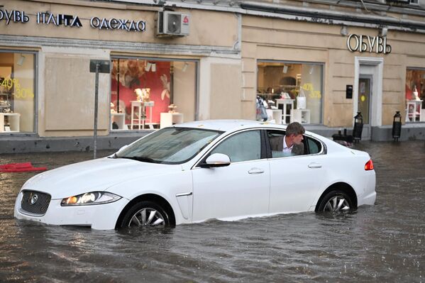 मास्को में भारी बारिश के कारण पानी से भरी सड़क पर एक कार। - Sputnik भारत