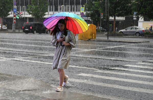 मास्को में बारिश के दौरान सड़क पार करती एक लड़की।  - Sputnik भारत