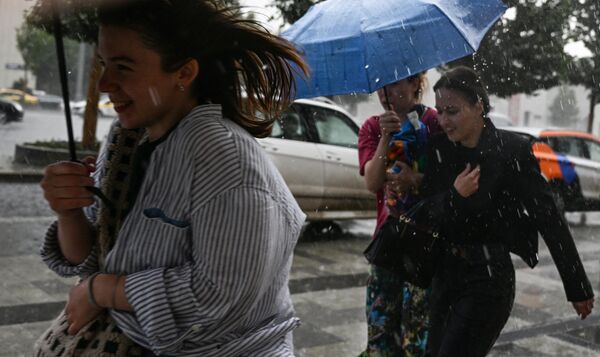 मास्को में बारिश के दौरान जुबोव्स्की बुलेवार्ड के किनारे पर दौड़ते लोग। - Sputnik भारत