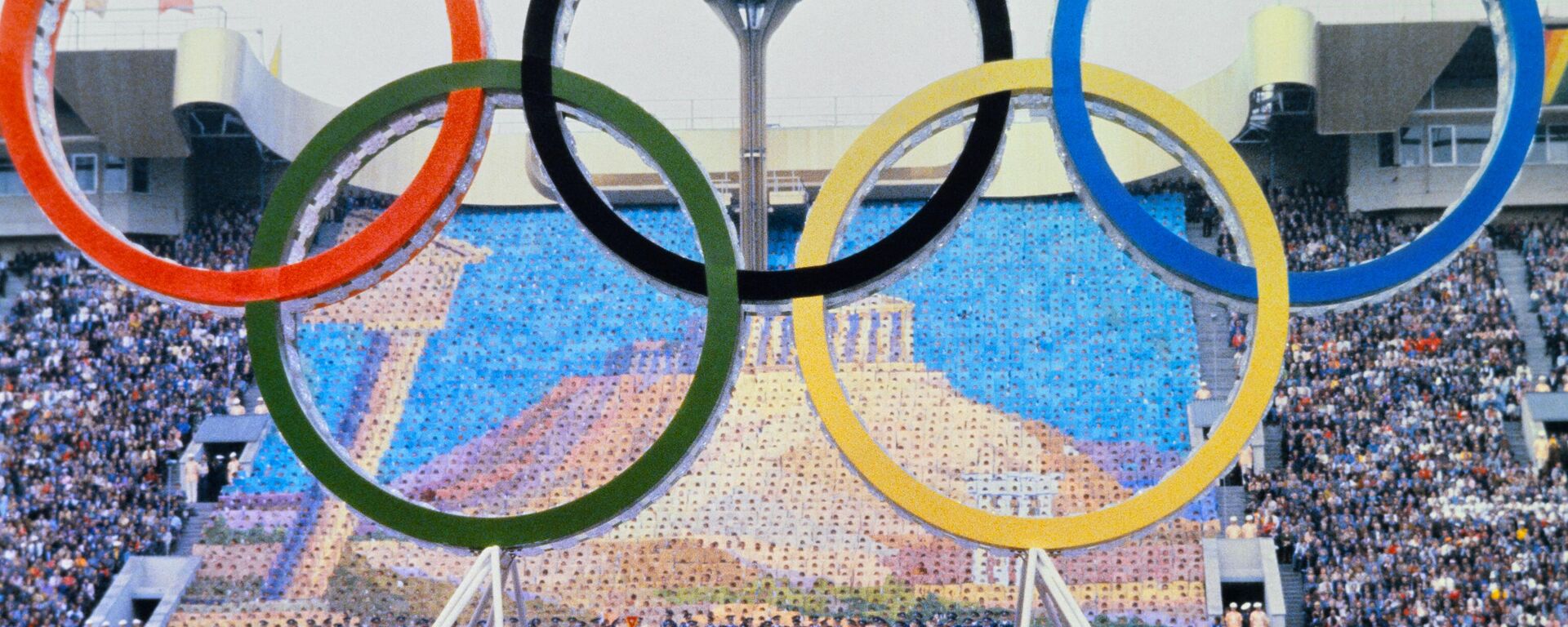 The Olympic rings stand out against a giant image of the Parthenon during the opening ceremony of the Moscow 1980 Summer Olympics, on July 19, 1980 at Moscow's Lenin Central Stadium. - Sputnik भारत, 1920, 19.07.2023