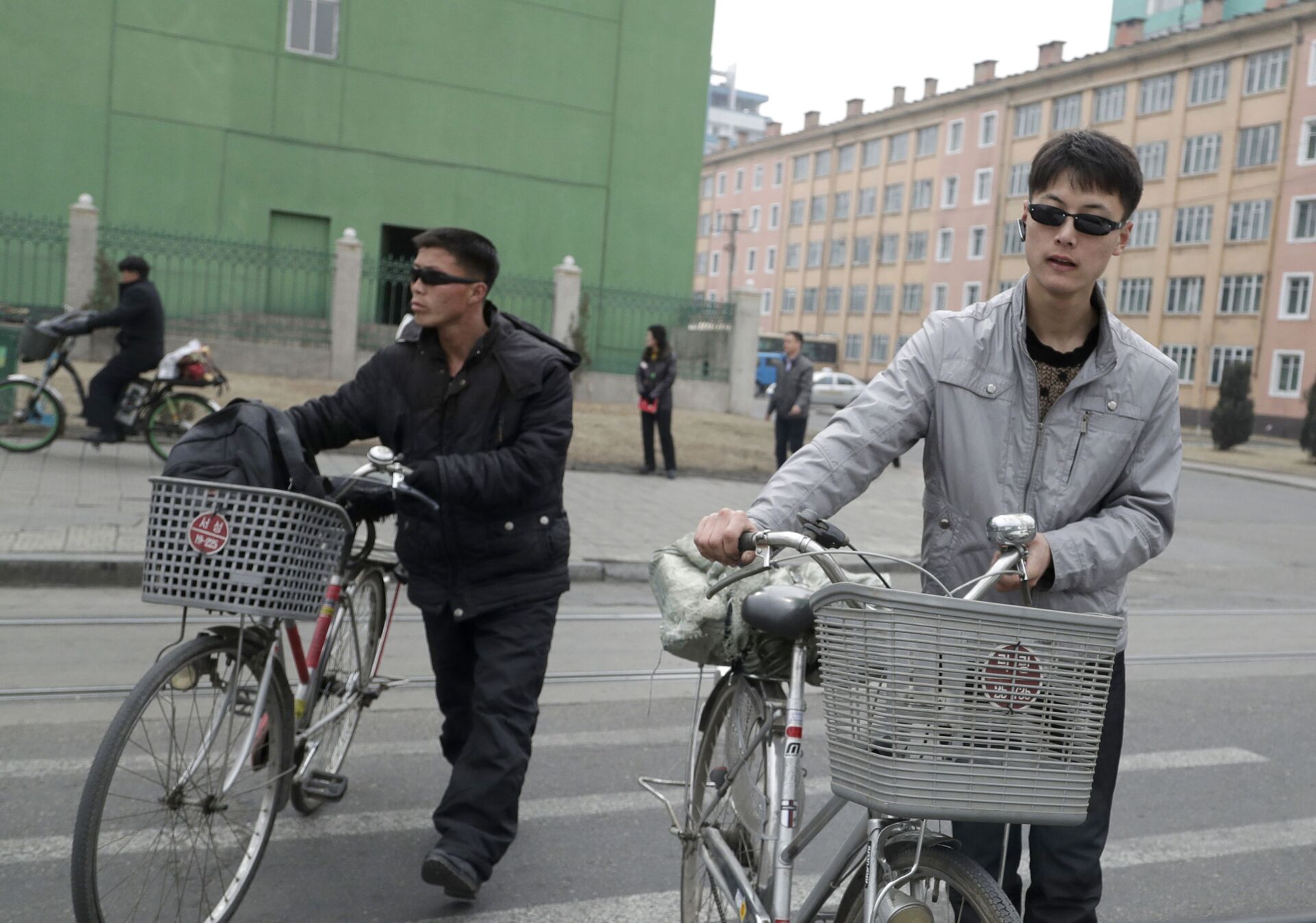 North Korean men push their bicycles as they cross a road in Pyongyang, North Korea, Saturday, March 9, 2019. - Sputnik भारत, 1920, 20.07.2023