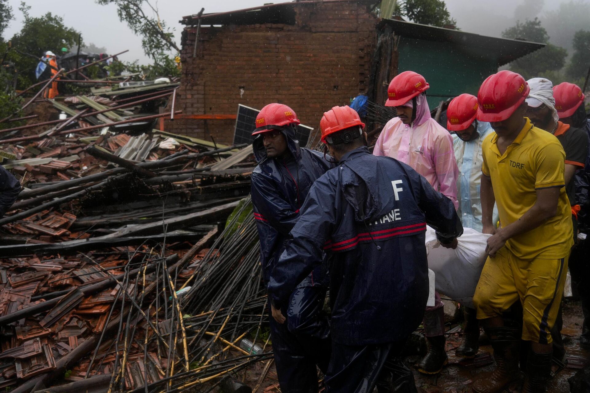 Rescuers carry the body of a victim at the site of a landslide triggered by torrential rains in Raigad district, western Maharashtra state - Sputnik India, 1920, 21.07.2023