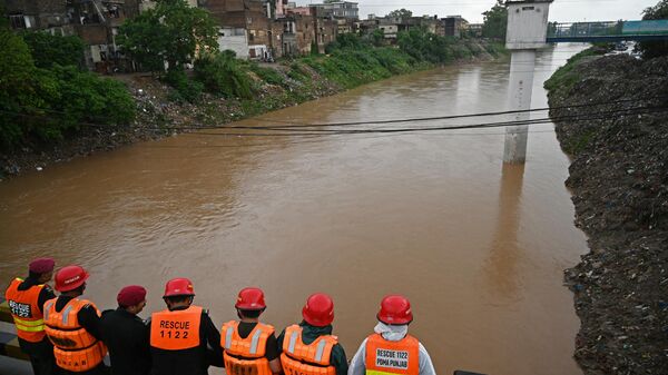 Rescue workers monitor the flood situation from a bridge built over a stream in Rawalpindi on July 19, 2023. More than 14,000 people and their cattle were evacuated from villages in eastern Pakistan, authorities said on July 18, following the arrival of monsoon rains across South Asia.  - Sputnik India
