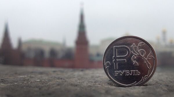 A Russian ruble coin is pictured in front of the Kremlin in in central Moscow, on November 6, 2014 - Sputnik भारत