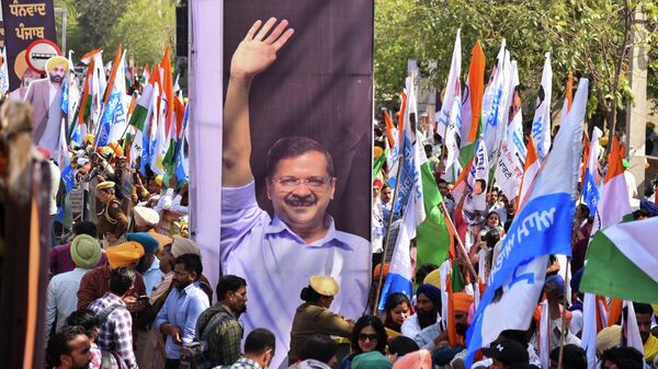 Supporters gather next to a photograph of Aam Aadmi Party chief Arvind Kejriwal, during a road show as they celebrate party's victory in the state Assembly elections, in Amritsar, India - Sputnik India