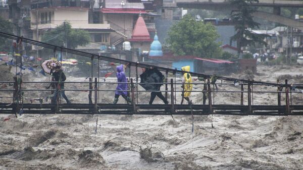 People walk through a bridge across River Beas swollen due to heavy rains in Kullu District, Himachal Pradesh - Sputnik India