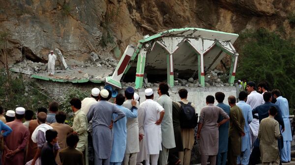 People Stand and watch the damaged mosque after a suicide bomber attack inside a roadside mosque in the Khyber district in Khyber Pakhtunkhwa province, of Pakistan, Tuesday,  July 25, 2023. A suicide bomber blew himself up inside a roadside mosque when a police officer tried to arrest him after a chase in northwestern Pakistan near the Afghan border on Tuesday, killing the officer, police said. - Sputnik भारत