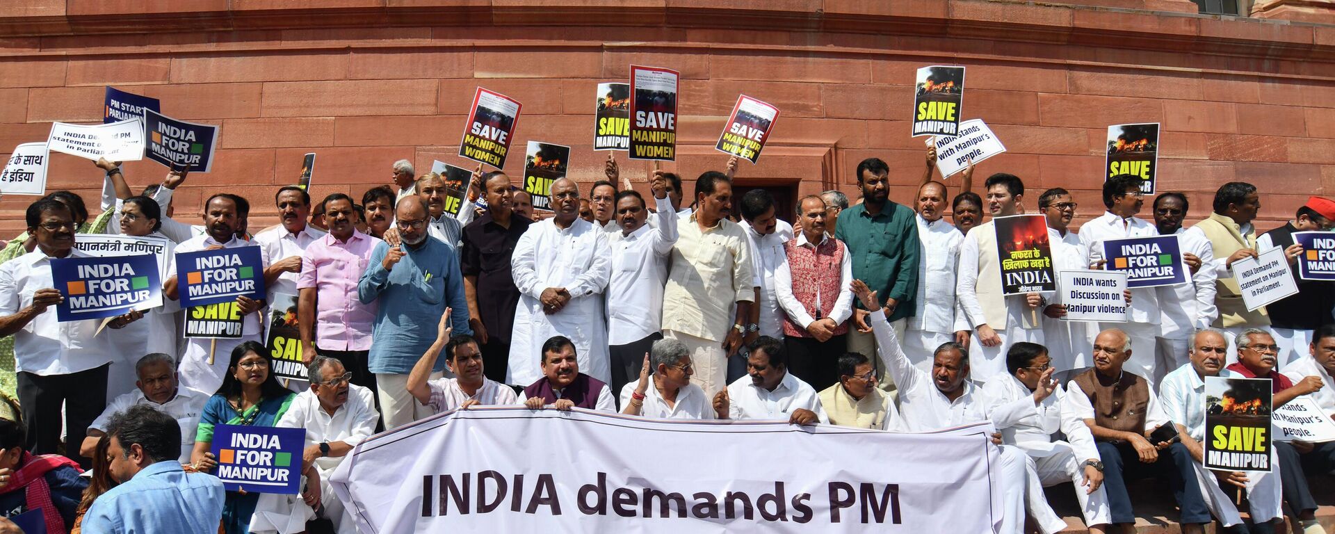 Opposition lawmakers demanding a statement from Prime Minister Narendra Modi on the violence in Manipur state carry placards and a banner with name of INDIA outside the Parliament building in New Delhi, India, Monday, July 24, 2023. India’s fractured opposition parties have joined forces in a rare show of unity and formed an alliance called 'INDIA' to unseat the popular but polarizing prime minister Narendra Modi and his Hindu nationalist Bharatiya Janata Party. Last week, more than two dozen parties joined the alliance, named the Indian National Developmental Inclusive Alliance which is called INDIA for short. - Sputnik भारत, 1920, 26.07.2023