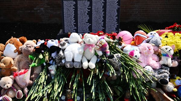 Flowers and toys stacked in front of the Donbass victims' memorial on a square in the Donetsk People's Republic - Sputnik India