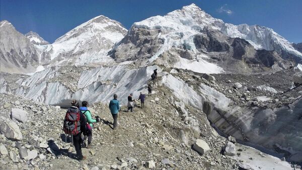 In this Monday, Feb. 22, 2016 file photo, trekkers pass through a glacier at the Mount Everest base camp, Nepal. One-third of Himalayan glaciers will melt by the end of the century due to climate change, threatening water sources for 1.9 billion people, even if current efforts to reduce climate change succeed, according to an assessment released Monday, Feb. 4, 2019. by the International Centre for Integrated Mountain Development.  - Sputnik भारत