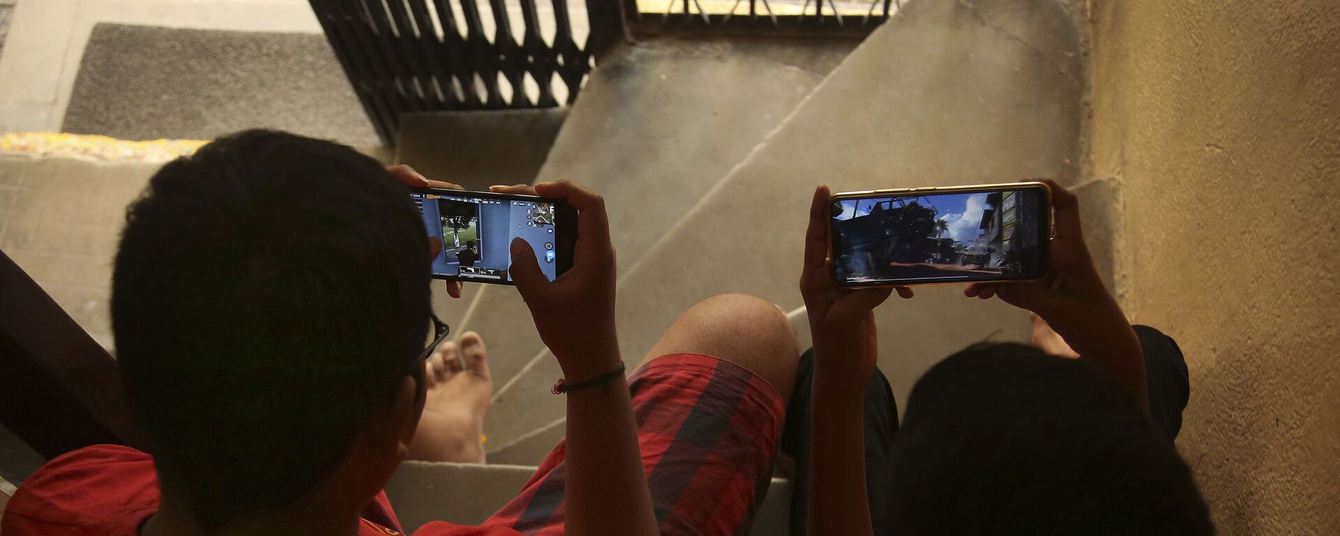 Indian children play online game PUBG on their mobile phones sitting on stairs outside their house  in Hyderabad, India, Friday, April 5, 2019.  - Sputnik India, 1920, 29.07.2023