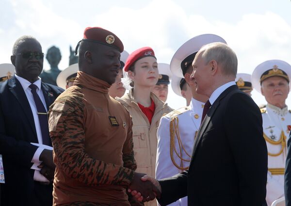 रूसी नौसेना दिवस के अवसर पर मुख्य नौसेना परेड में रूसी राष्ट्रपति व्लादिमीर पुतिन और अग्रभूमि बाईं ओर बुर्किना फासो गणराज्य के संक्रमणकालीन राष्ट्रपति इब्राहिम ट्रोरे, 30 जुलाई, 2023 - Sputnik भारत