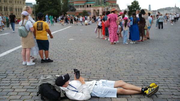 Иностранный турист отдыхает на Красной площади в Москве - Sputnik भारत