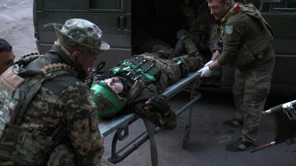 Ukrainian military medics carry a wounded Ukrainian serviceman delivered from a front line position to a stabilization point.  - Sputnik भारत