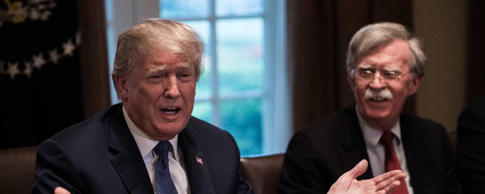 US President Donald Trump speaks during a meeting with senior military leaders at the White House in Washington, DC, on April 9, 2018. At right is new National Security Advisor John Bolton. (Photo by NICHOLAS KAMM / AFP) - Sputnik भारत, 1920, 03.11.2023