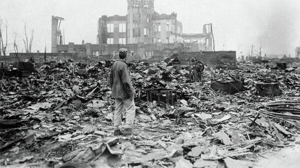 An allied correspondent stands in the rubble in front of the shell of a building that once was a movie theater in Hiroshima, Japan, a month after the first atomic bomb ever used in warfare was dropped by the U.S. on Aug. 6, 1945 - Sputnik भारत