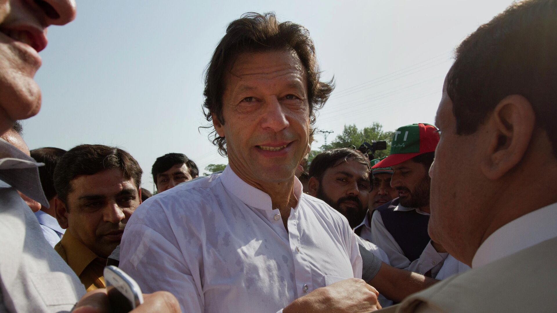 Pakistan's ex-cricket star-turned-politician Imran Khan, center, is surrounded by his supporters as he arrives to lead what organizers are calling the peace march, in Islamabad, Pakistan, Saturday, Oct. 6, 2012. - Sputnik भारत, 1920, 22.12.2023