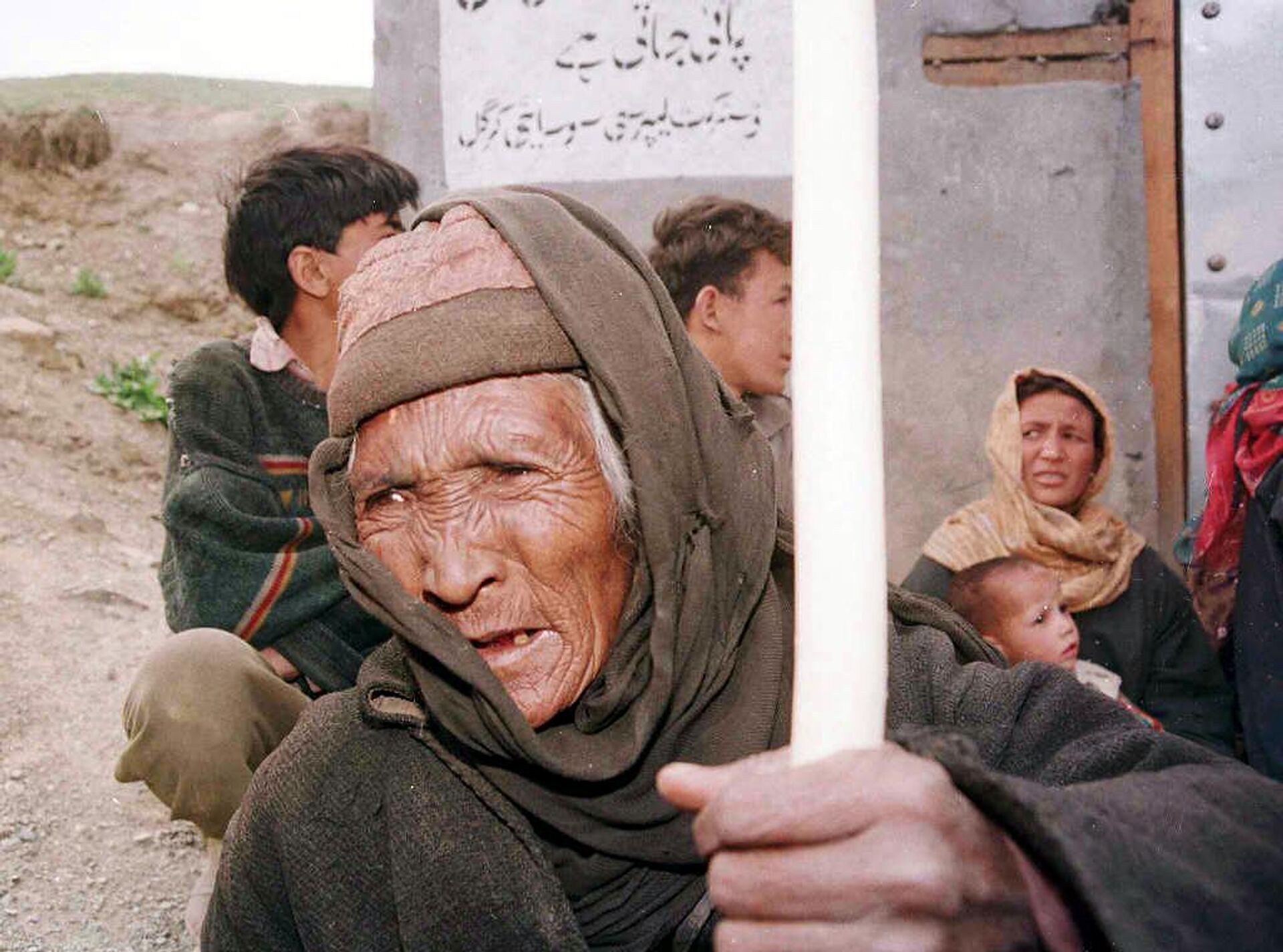 An old woman leaves her home in Kargil 26 May 1999 after exchanges of heavy artillery between Pakistan and India in Kashmir.   - Sputnik भारत, 1920, 07.08.2023
