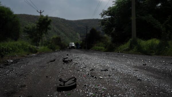 A sandal lies on a road next to scattered glass from vehicles vandalized during communal clashes in Nuh in Haryana state, India, Tuesday, Aug. 1, 2023. - Sputnik India