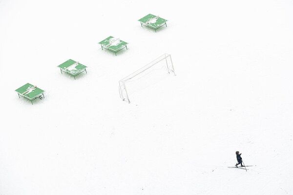 प्राथमिक विद्यालय का छात्र खाली स्कूल स्टेडियम में स्कीइंग कर रहा है। - Sputnik भारत