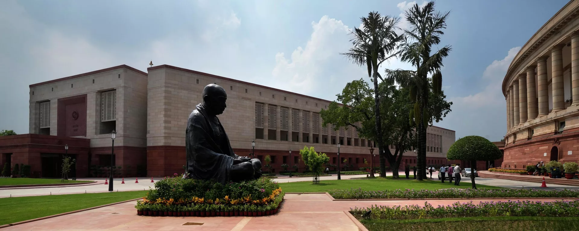 A statue of Mahatma Gandhi sits between the old and new Parliament House on the opening day of the monsoon session of the Indian parliament, in New Delhi, India - Sputnik भारत, 1920, 15.03.2024