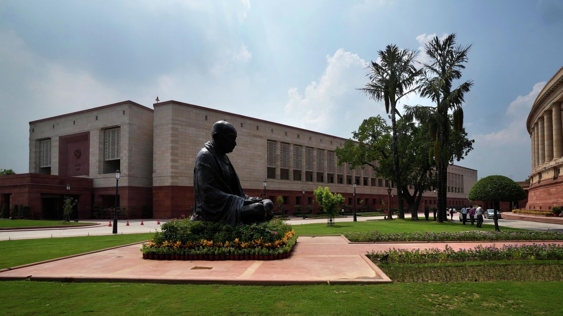 A statue of Mahatma Gandhi sits between the old and new Parliament House on the opening day of the monsoon session of the Indian parliament, in New Delhi, India - Sputnik भारत, 1920, 12.09.2023