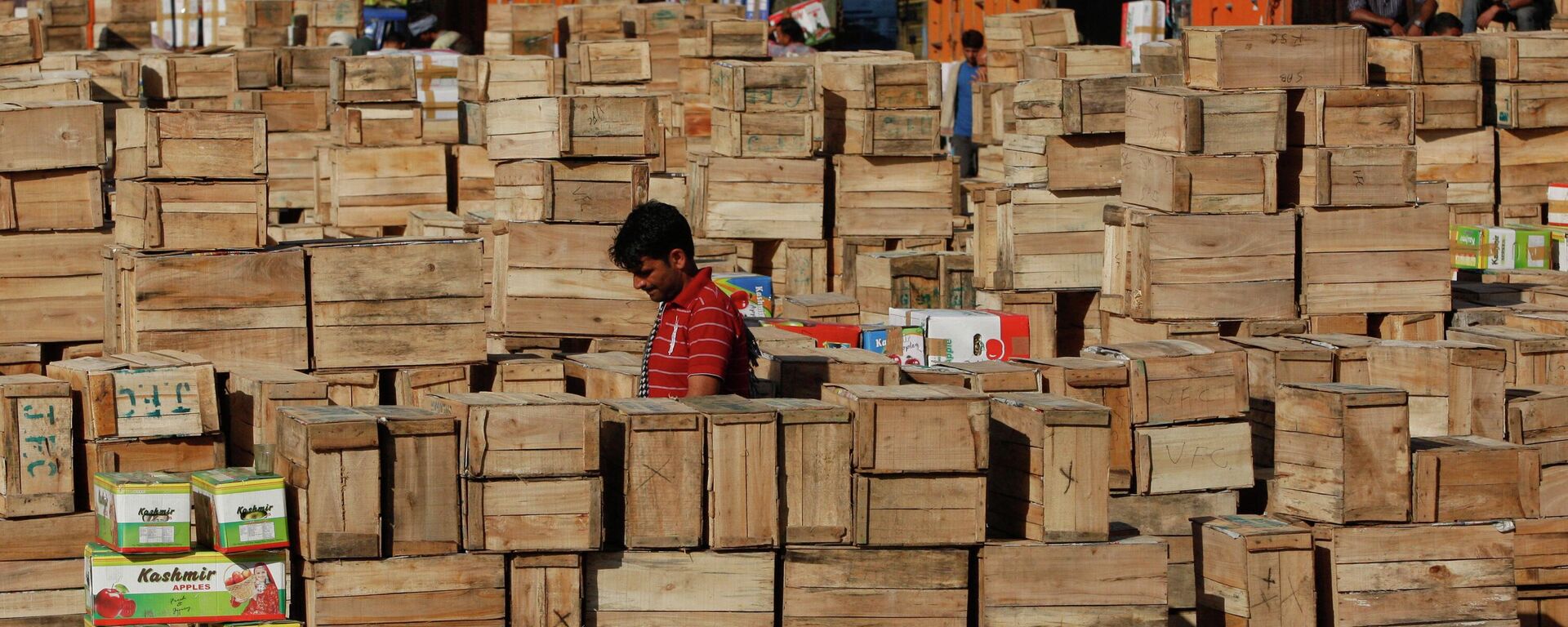 An Indian laborer counts boxes containing apples at wholesale market on the outskirts of Jammu, India, Wednesday, Sept.30, 2015.  - Sputnik India, 1920, 22.08.2023