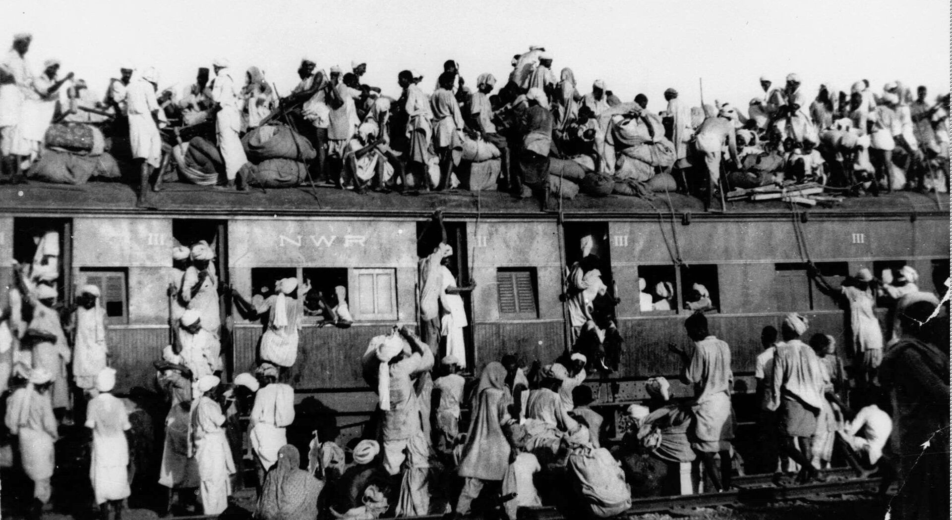 In this September 1947, file photo hundreds of Muslim refugees crowd on top a train leaving New Delhi for Pakistan. After Britain ended its colonial rule over the Indian subcontinent, two independent nations were created in its place _ the secular, Hindu-majority nation of India, and the Islamic republic of Pakistan. The division, widely referred to as Partition, sparked massive rioting that killed up to 1 million, while another 15 million fled their homes in one of the world’s largest ever human migrations. (AP Photo, File) - Sputnik India, 1920, 10.08.2023