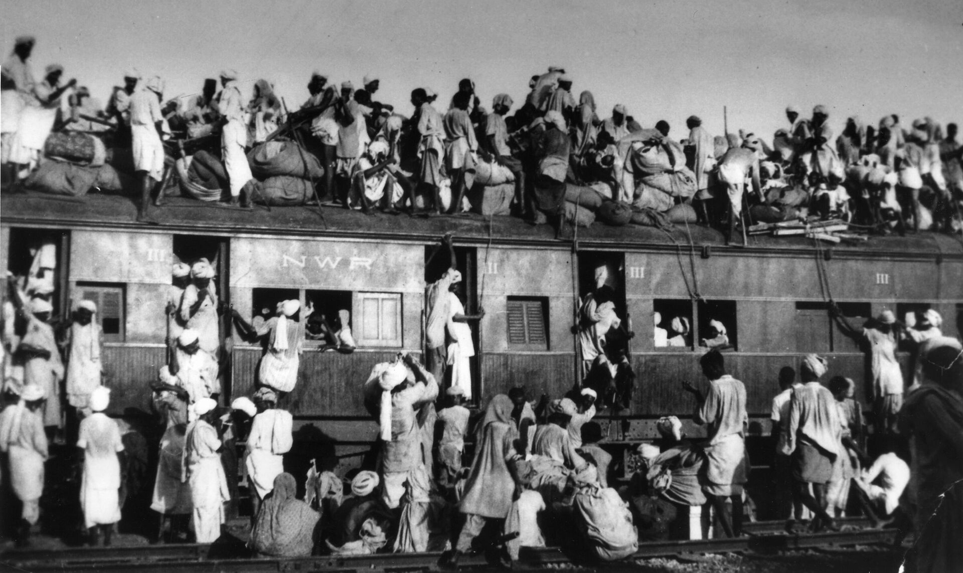 In this Sept. 19, 1947 file photo, Muslim refugees sit on the roof of an overcrowded coach railway train near New Delhi in trying to flee India. - Sputnik India, 1920, 14.08.2023