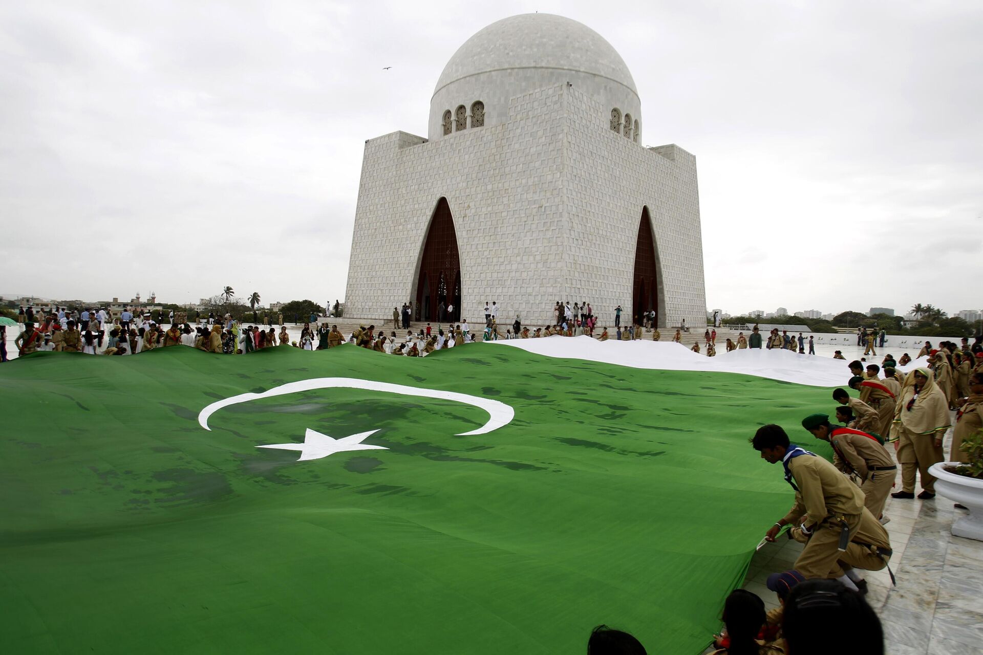 Students hold a giant representation of a Pakistani flag to celebrate the 68th Independence Day at the mausoleum of  Muhammad Ali Jinnah - Sputnik India, 1920, 14.08.2023