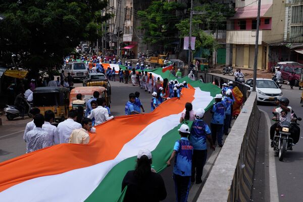 मंगलवार, 15 अगस्त, 2023 को हैदराबाद, भारत में स्वतंत्रता दिवस समारोह के दौरान लोग विशाल भारतीय झंडे के साथ रैली में भाग ले रहे हैं। (AP Photo/Mahesh Kumar A.) - Sputnik भारत