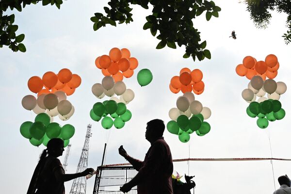 15 अगस्त, 2023 को चेन्नई में देश के 77वें स्वतंत्रता दिवस समारोह के अवसर पर समारोह के दौरान लोग भारतीय राष्ट्रीय झंडे के रंगों में सजाए गए गुब्बारों के पास खड़े हैं। (AFP 2023R. Satish Babu) - Sputnik भारत