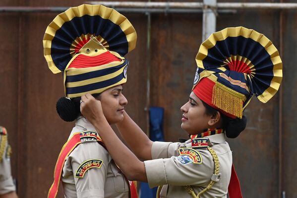 15 अगस्त, 2023 को हैदराबाद में भारत के 77वें स्वतंत्रता दिवस के समारोह में मार्च करने से पहले भारतीय रेलवे सुरक्षा बल (RPF) की एक जवान दूसरी को हेडवियर समायोजित करने में मदद कर रही है। (AFP 2023Noah Seelam) - Sputnik भारत